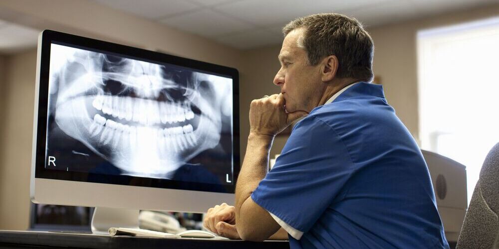 a dental specialist in turkey looking at an x-ray